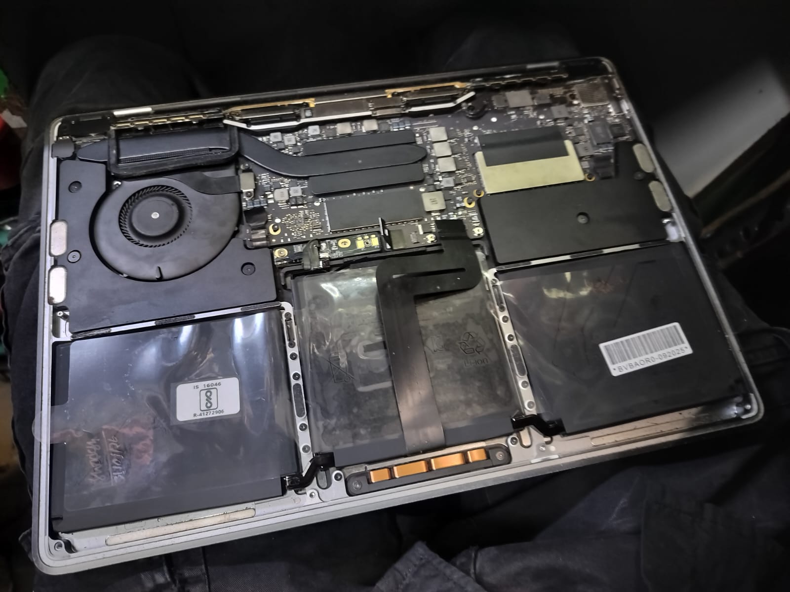Open MacBook placed for internal board inspection during service