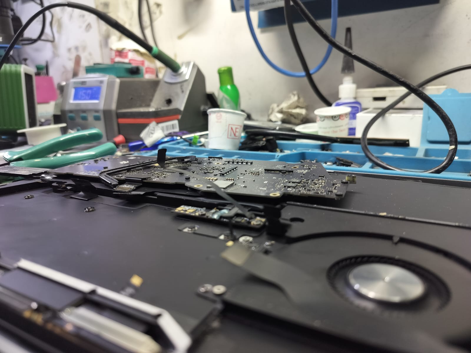 MacBook motherboard repair underway on a workshop bench