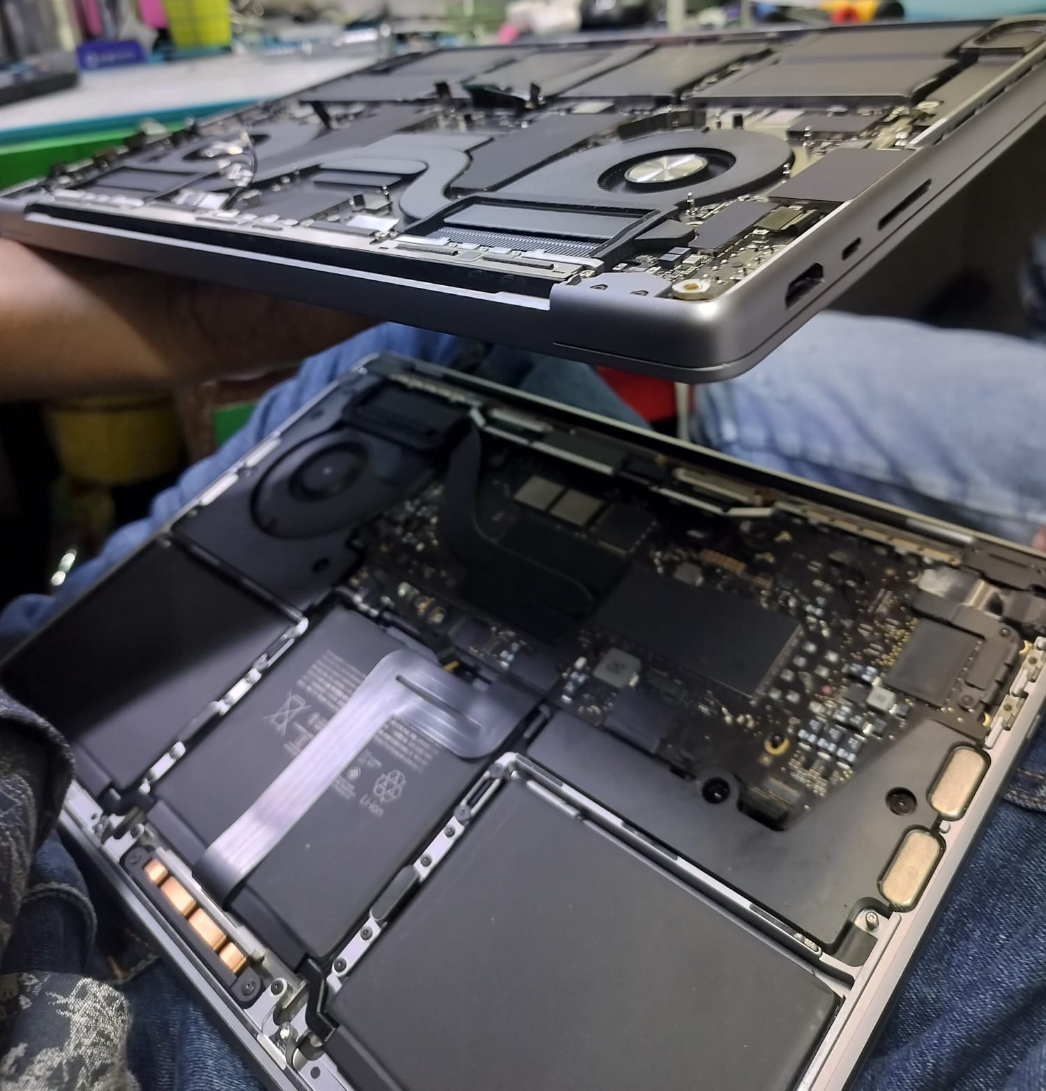 Two MacBook units opened side by side to show internal repair work