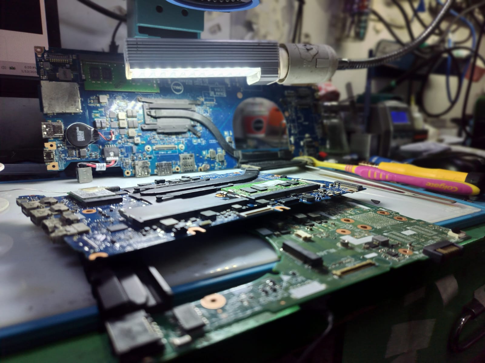 Laptop motherboard placed under repair lighting for component-level diagnostics