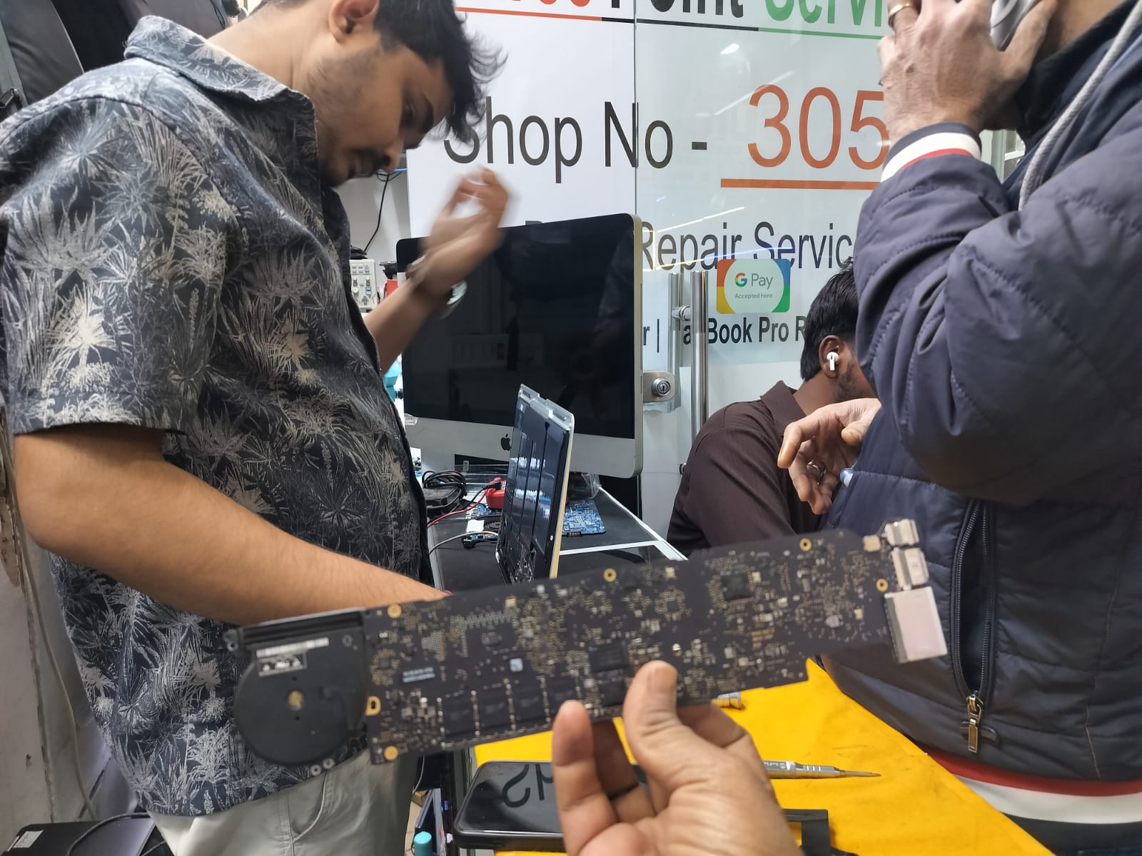 Repair staff at the CompSense workshop with a motherboard being reviewed during service support